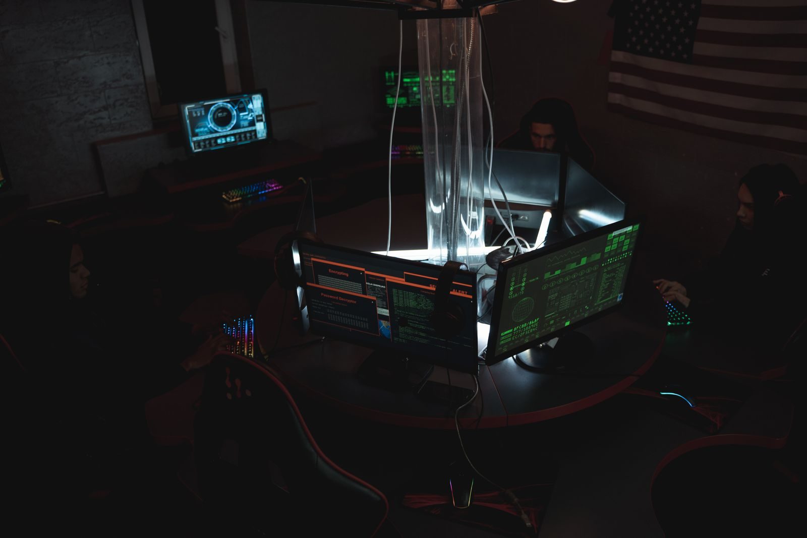 Team van cyberbeveiligers werkt samen in een schemerige kamer vol computers.